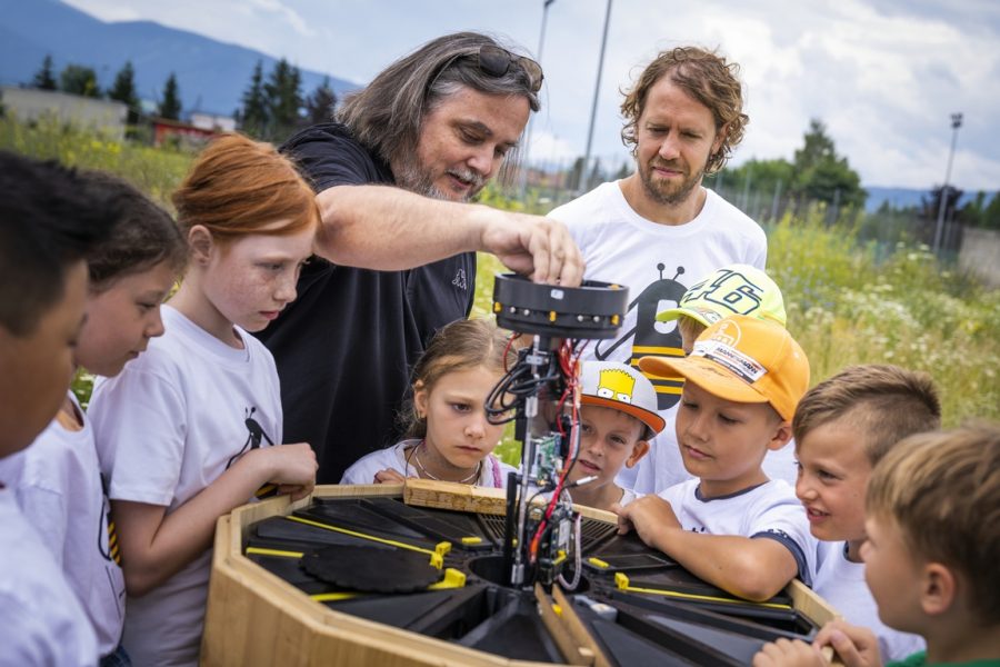 Biologe Prof. Dr. Thomas Schmickl erklärt Sebastian Vettel und den Kindern die Technik im "Bienenstock der Zukunft". (Foto Philipp Platzer)