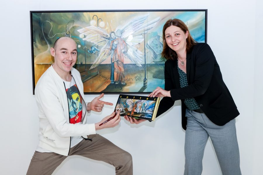 Tom Lohner gestaltete das Titelbild zu Zotter Jubiläums-Schokolade 100 Jahre Caritas. Künstler Tom Lohner und Caritasdirektorin Nora Tödtling-Musenbichler bei der Präsentation. (Foto Stefan Pajman)