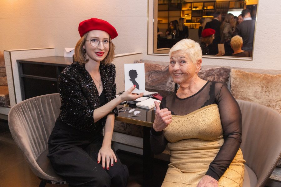 Die Gäste konnten sich ihr Portrait der Scherenschnittkünstlerin Michaela Hofer mit nach Hause nehmen. Im Bild mit Jazz Gitti. (Foto Monika Fellner)
