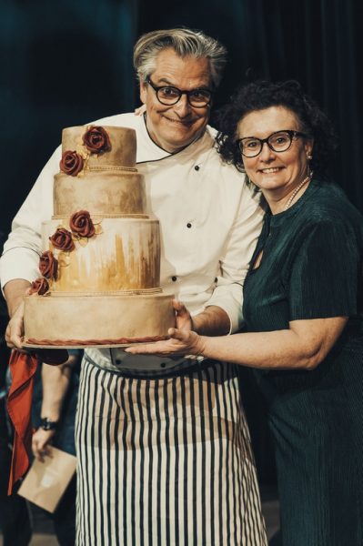 Die 'Jedermann-Tischgesellschaftstorte' in den Händen von Moderator und Schauspieler Dorian Steidl und Konditorin Lilli Philipp. (Foto @matthiasklopp)